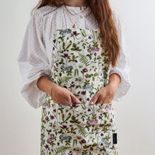 Load image into Gallery viewer, Person wearing a floral apron with a white background